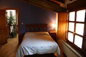 OjacastroCasa Rural Ugarte Ojacastro的一间卧室设有一张床和两个窗户。