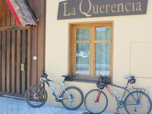 La Pradera de Navalhorno喹啉西亚瓦尔森酒店的两辆自行车停在大楼的一侧