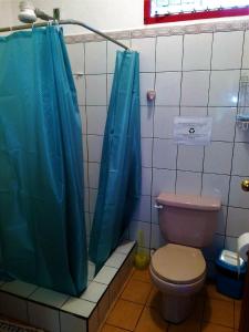 卡维塔Cabinas Caribe Luna的浴室设有卫生间和蓝色的浴帘。