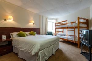 福克斯通格兰德柏思汀酒店的一间卧室配有两张双层床和电视