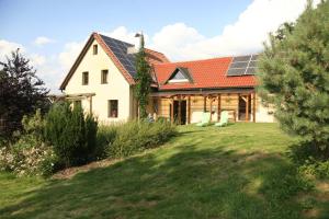 StvolínkyTaneček - malý apartmán u rodinného domu的屋顶上设有太阳能电池板的房子