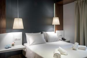 雅典雅典AD豪华套房酒店的一间卧室配有带白色床单和枕头的床。