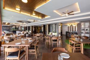 邦涛海滩普吉岛班陶海滩丽晶酒店的餐厅设有木桌、椅子和沙发。