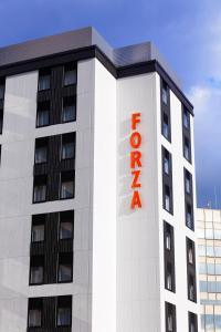 福冈HOTEL FORZA HAKATA-GUCHI的上面有红色酒店标志的白色建筑