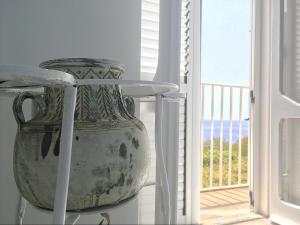 马拉泰亚Dimore Santojanni - La Casa sul Porto的坐在窗边桌子上的一个大花瓶