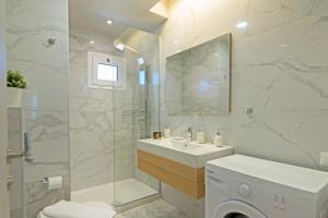 加藤-达拉特索Sonja Beachfront Apartments的白色的浴室设有水槽和淋浴。