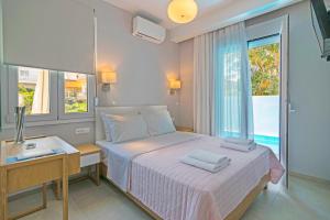 加藤-达拉特索Sonja Beachfront Apartments的一间卧室配有一张床、一张书桌和一个窗户。