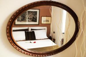 热那亚Ipazia House的镜子和床上的床铺