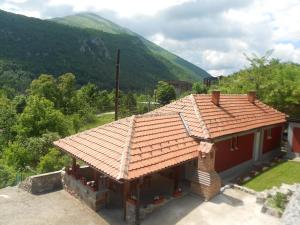 利塔尼Vikendica RTANJ的一座有红色屋顶的房子,后面有山