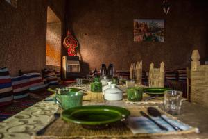 斯库拉Skoura Lodge的一张桌子,上面有绿板和餐具