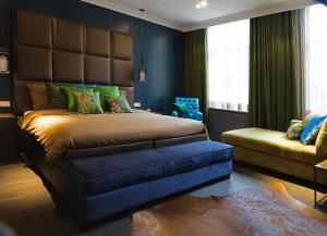 奥斯特韦克奥斯特韦克雷霍夫酒店的一间卧室配有一张大床和一张沙发