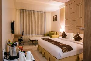 纳西克Hotel Grand Rio的一间酒店客房,房内配有一张大床