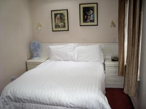 希钦费斯酒店的卧室配有白色的床和墙上的两张照片