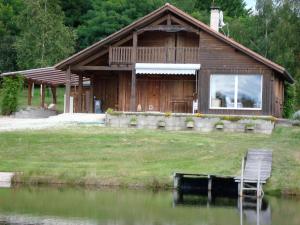 AugignacLieux-au-lac的湖畔木屋,配有椅子