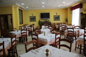 圣地亚哥德拉里贝拉Hotel Albohera的一间带桌椅和电视的用餐室