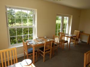 Leck吉尔贝克之家住宿加早餐旅馆的用餐室设有桌椅和窗户。