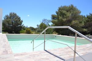 法维尼亚纳Plaia Resort的游泳池旁的带金属扶手的游泳池
