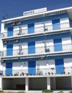 沃洛斯To Giouli的酒店配有蓝色和白色的窗户和阳台。