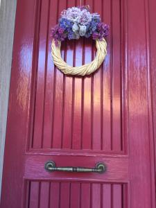马帝斯兹罗La Perla del Mare的红色的门,上面有花环