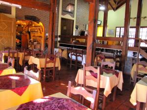 梅洛Hotel Altos del Rincon的一间在房间内配有桌椅的餐厅
