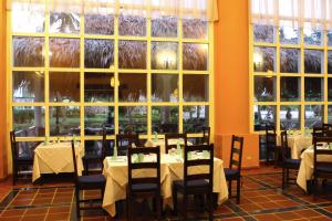 La Playa玛格丽塔岛赫斯珀里亚酒店的用餐室配有桌椅和大窗户