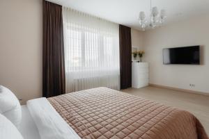 敖德萨Arcadia Villa Apartments的一间卧室配有一张床和一台电视