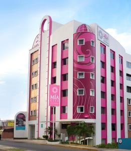 比亚埃尔莫萨Mia City Villahermosa的粉红色和白色的建筑,上面有标志