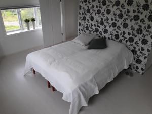 奥萨Orsastuguthyrning-Digerberget的一间卧室配有一张带白色床单的床和一扇窗户。