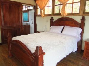 埃斯特利Paysage Cache的一间卧室配有木制床、白色床单和窗户