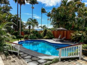 希洛兰花树住宿加早餐旅馆的棕榈树庭院内的游泳池