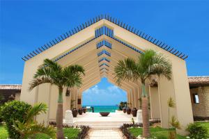 Kohama南群星酒店的一座棕榈树环绕的建筑,位于大海前