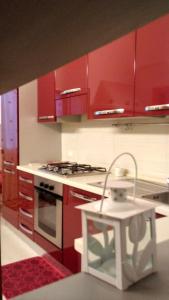 滨海波利尼亚诺La Dimora del Gelso Rosso的厨房配有红色橱柜和炉灶烤箱