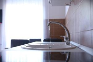 弗尔尼亚奇卡矿泉镇Apartments Lukic的一个带椅子的房间的白色水槽