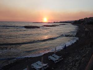 阿西亚罗利特帕尔梅住宅酒店的日落时在海滩上摆放两把躺椅