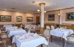 奥洛特里夫鲁威亚酒店的一间设有白色桌椅的用餐室
