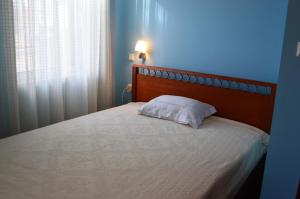 梅加尼西岛Captain's House的卧室配有一张带白色枕头的床