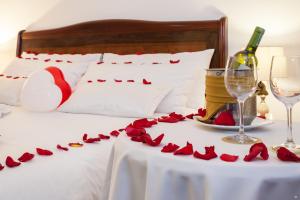 波哥大大使馆公园酒店的一张桌子上的红玫瑰床和一瓶葡萄酒