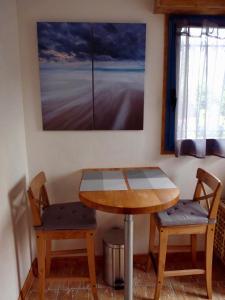 圣吕奈尔Suite à 800m de la plage的画室里的一张桌子和两把椅子