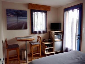 圣吕奈尔Suite à 800m de la plage的一间卧室配有一张床、一张桌子和一台微波炉