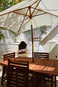阿尔贝罗贝洛 阿尔贝罗贝洛特鲁利度假屋的一张带雨伞和比萨饼烤箱的木桌
