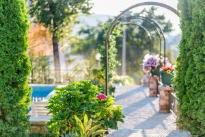 赫尔采格诺维Villa Besha的一个带长凳和鲜花的花园和一个游泳池