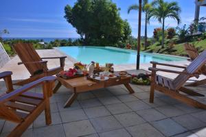Djamandjary玛希塔萨拉酒店的一个带两把椅子和一张桌子的庭院,毗邻一个游泳池
