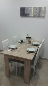 杜格普利耶Apartment Smodlaka的一张木桌,配有椅子和盘子,酒杯