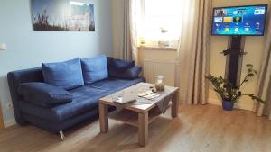宾茨Haus OF的客厅配有蓝色的沙发和茶几
