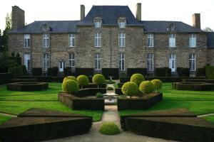 Val CouesnonChâteau de La Ballue - Teritoria的一座大型砖砌建筑,前面设有花园