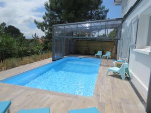 villa 12 pers climatisée, piscine chauffée couverte ou non,2km mer, golf, jardin内部或周边的泳池