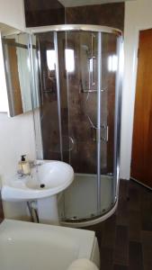 Balallan7 Habost的一间带玻璃淋浴和水槽的浴室