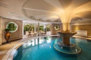 伊斯基亚Excelsior Belvedere Hotel & Spa的一座大型游泳池,在一座建筑中设有喷泉