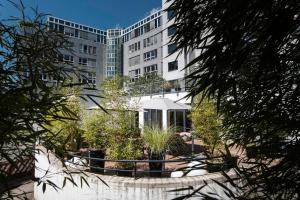 美因河畔法兰克福Pearl Design Hotel - Frankfurt City的建筑前带花园的建筑