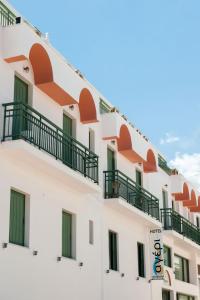 提诺斯Ageri Hotel的带阳台的建筑和酒店标志